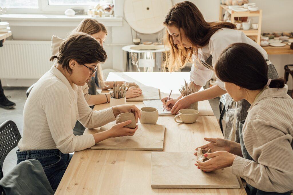 A group of young women work in a pottery workshop.